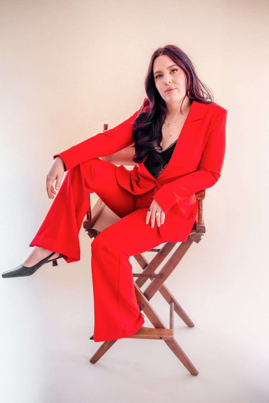 Sydney Mohni in a red suit in a director's chair
