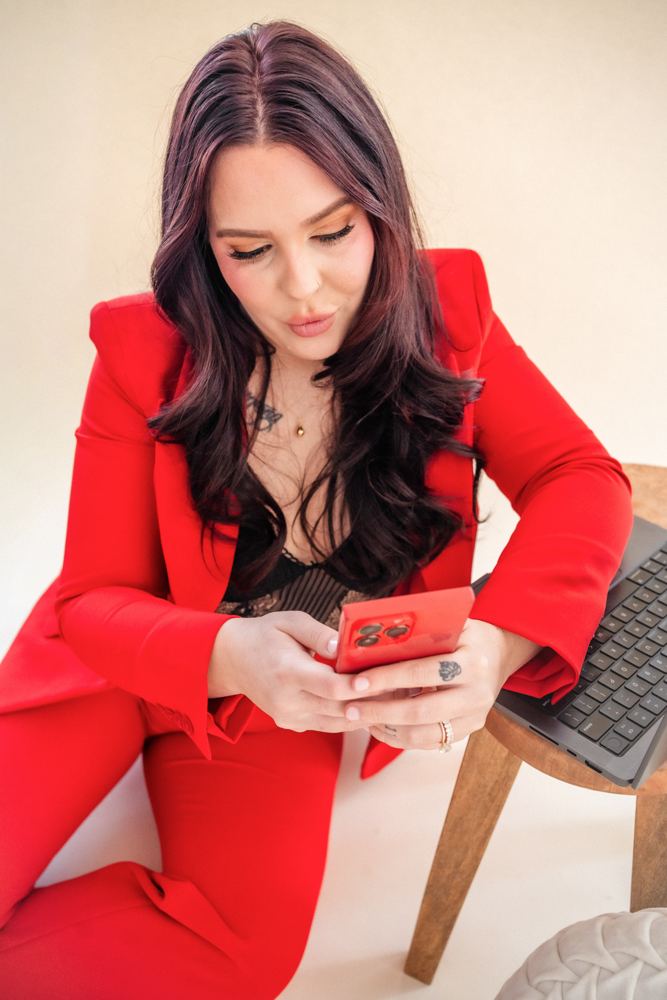 Sydney Mohni on her phone beside a laptop