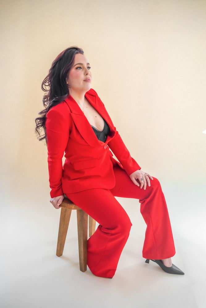 Sydney Mohni seated in a red suit